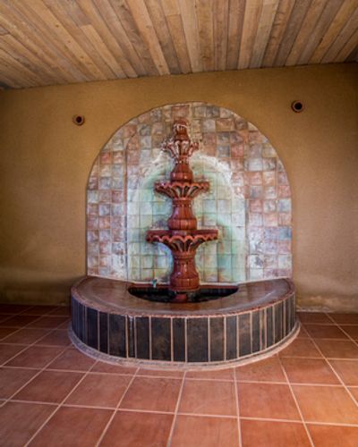 A fountain in the middle of a room with tile.