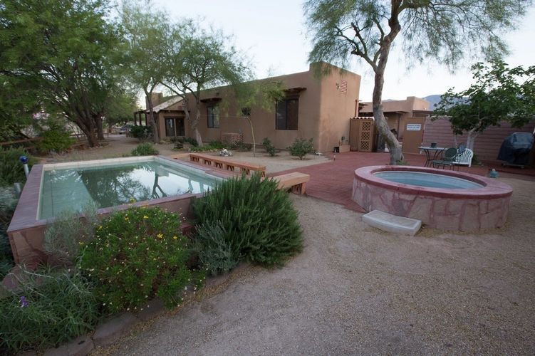 A pool and hot tub in the middle of a yard.