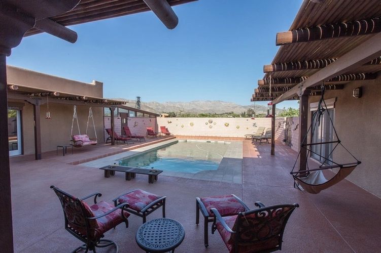 A pool with chairs and tables in the middle of it