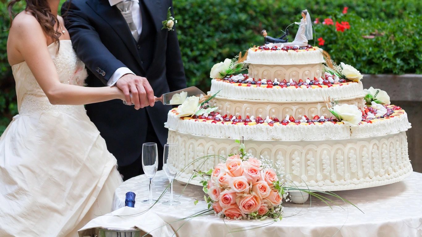 A couple cutting their wedding cake together.