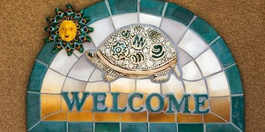 A mosaic of a turtle with the word " welcome ".